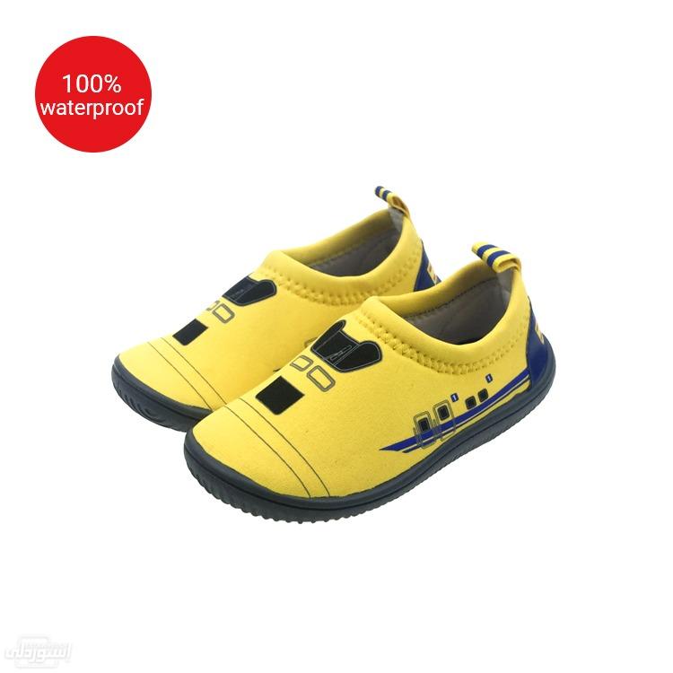 حذاء اطفالي للجنسين اصفر اللون عليه رسومات مختلفة بالاسود من القماش 