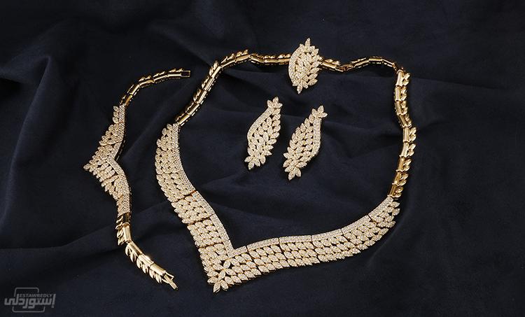 طقم مجوهرات مكون من أربع قطع عقد وخاتم وحلق وأنسيال ذات تصميمات عصرية نوعية رفيعة للمناسبات وافراح الافراح ذو لون ذهبي 