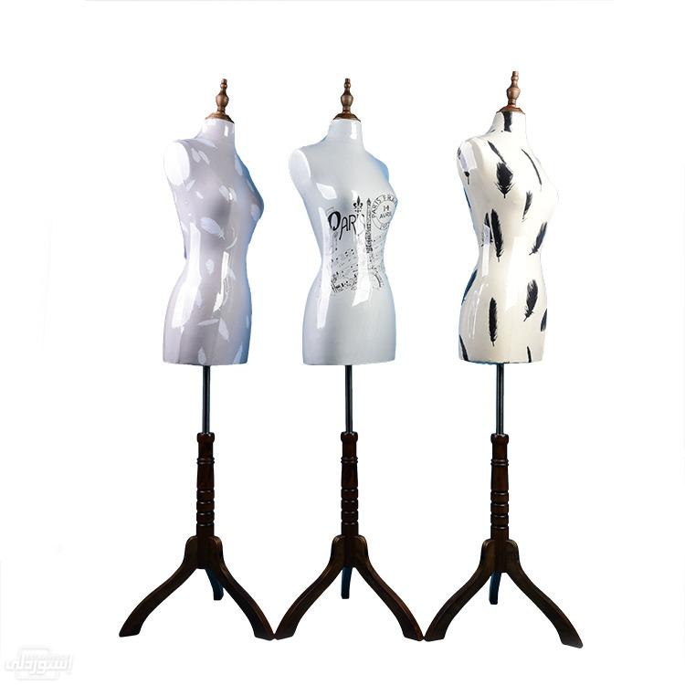 حامل ثلاثى القوائم عارضة للملابس النسائية بيضاء اللون وعليها رسومات نوعية رفيعة 